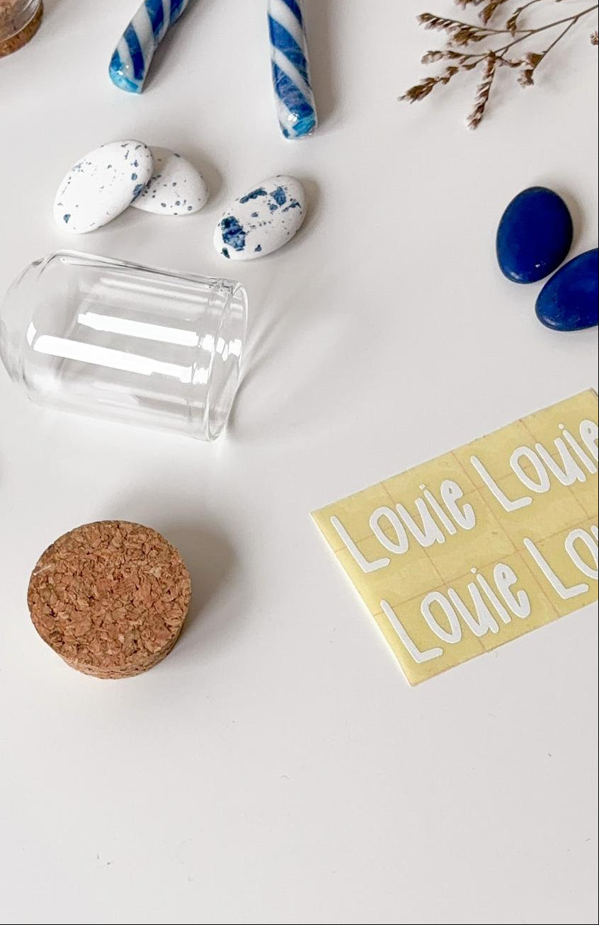 Zelf doopsuiker maken. Flatlay van doopsuiker materialen, vinylsticker, naamsticker voor doopsuiker - Atelier D